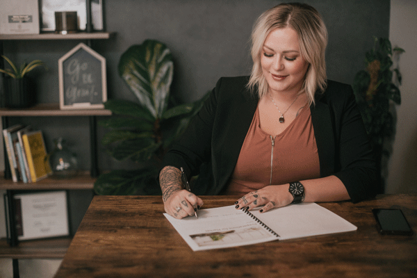 Kelsey Gebhardt sitting at a desk, signing papers